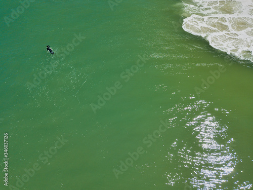 Surfers battle large waves near the shore of Island Beach State Park in New Jersey as they search for the ultimate wave seen from an aerial drone