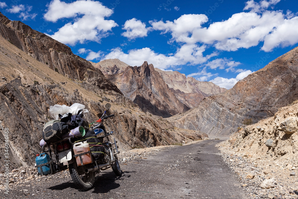 Bike travelling in Zanskar Valley, India. Travel by motorcycle in Ladakh, North India. Fully loaded touring bike on the road in Zanskar. Bike travelling in Zanskar Valley, India. Travel by motorcycle in Ladakh, North India. Fully loaded touring bike on the road in Zanskar.