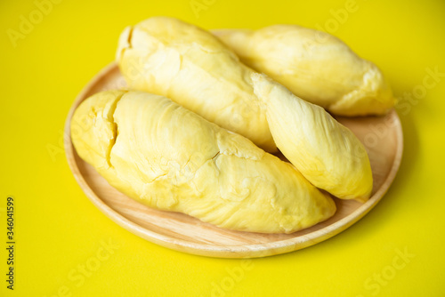 Ripe durian tropical fruit summer for sweet dessert or snack in Thailand - Durian fruit fresh from tree peel on wooden plate yellow background