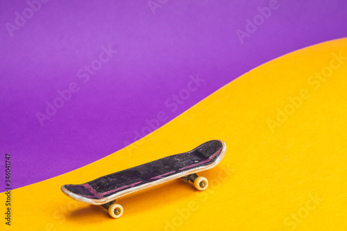 Фотография Small skateboard on color background