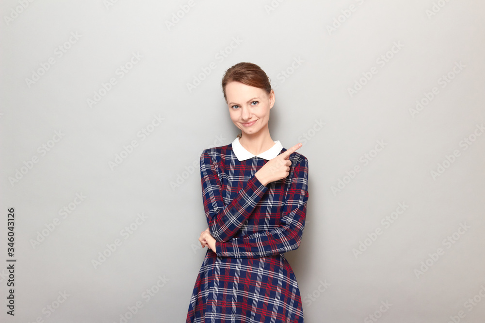 Portrait of cheerful young woman pointing with finger at copy space Portrait of cheerful young woman pointing with finger at copy space