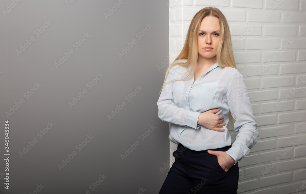 Young beautiful business girl stands on a gray-white background. Space for text. Young beautiful business girl stands on a gray-white background. Space for text.