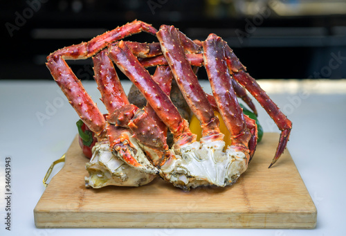 Steam Norwegian Red King Crab, Cooked Organic Alaskan King Crab Legs,Alaskan King Crab on vintage wooden plate. photo