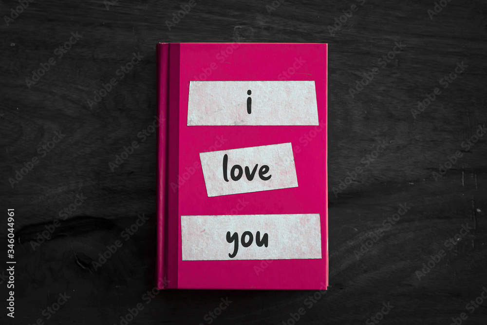 A pink book with a simple three worded message written on the front. A pink book with a simple three worded message written on the front.