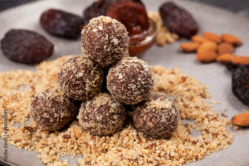 Energy balls on a plate during cooking  folded slide on a pillow of assorted crushed nuts