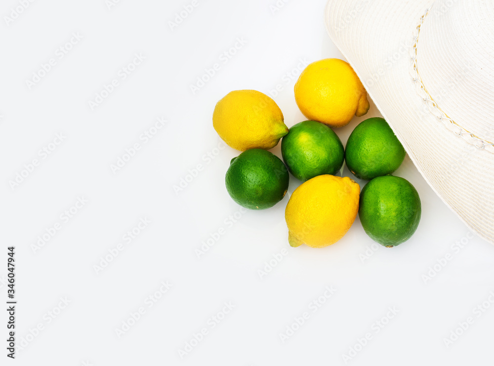fresh lemons and limes with sun hat on white background fresh lemons and limes with sun hat on white background
