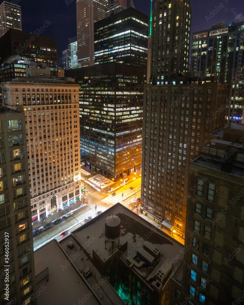 Downtown Chicago at night with busy streets and tall skyscraper buildings Downtown Chicago at night with busy streets and tall skyscraper buildings