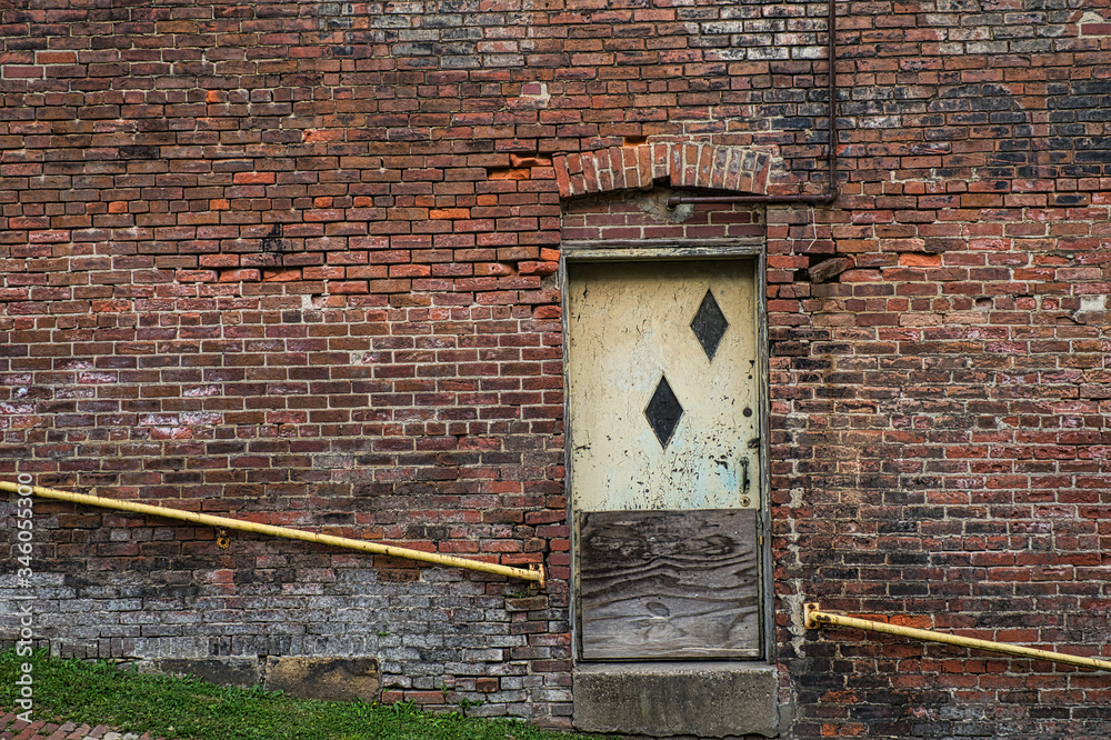 Old weathered door on brock building.