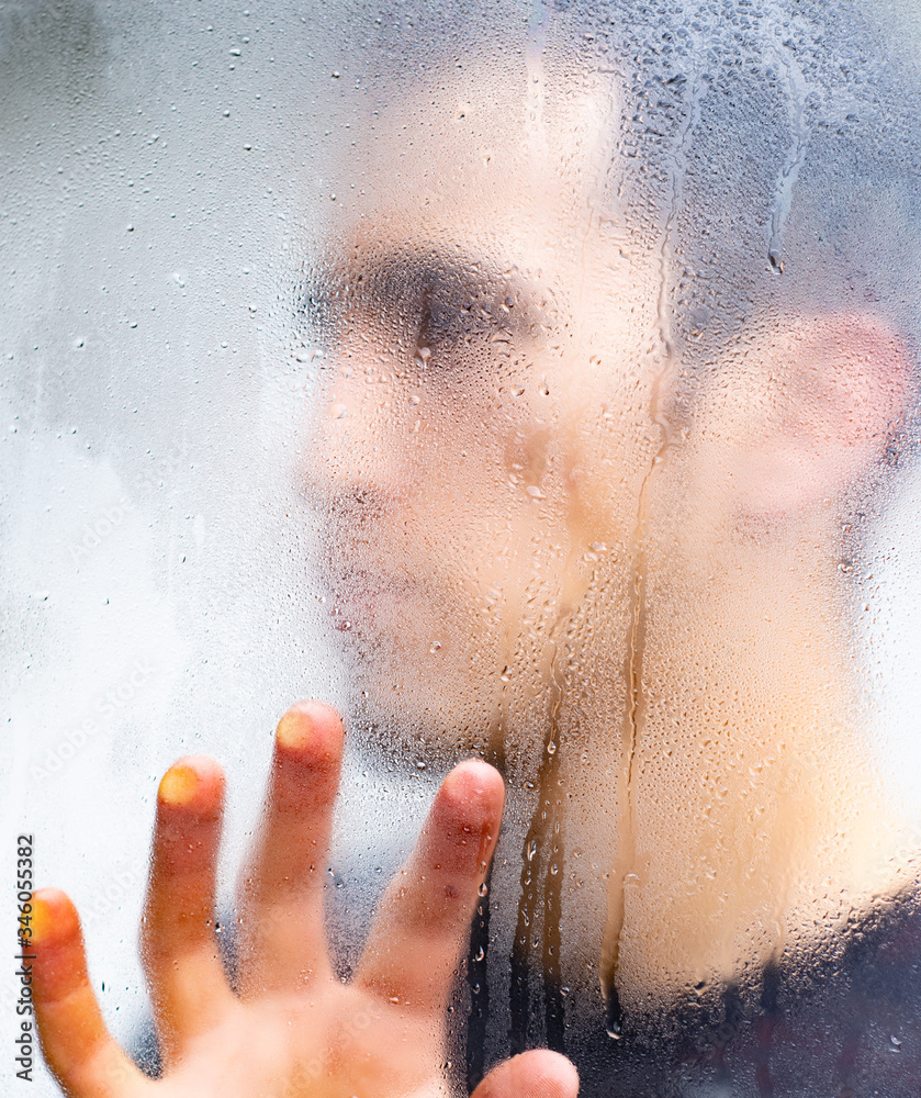man behind the window while it rains
