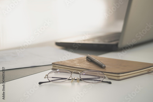 work from home, a glasses above laptop computer on a white modern business office desk