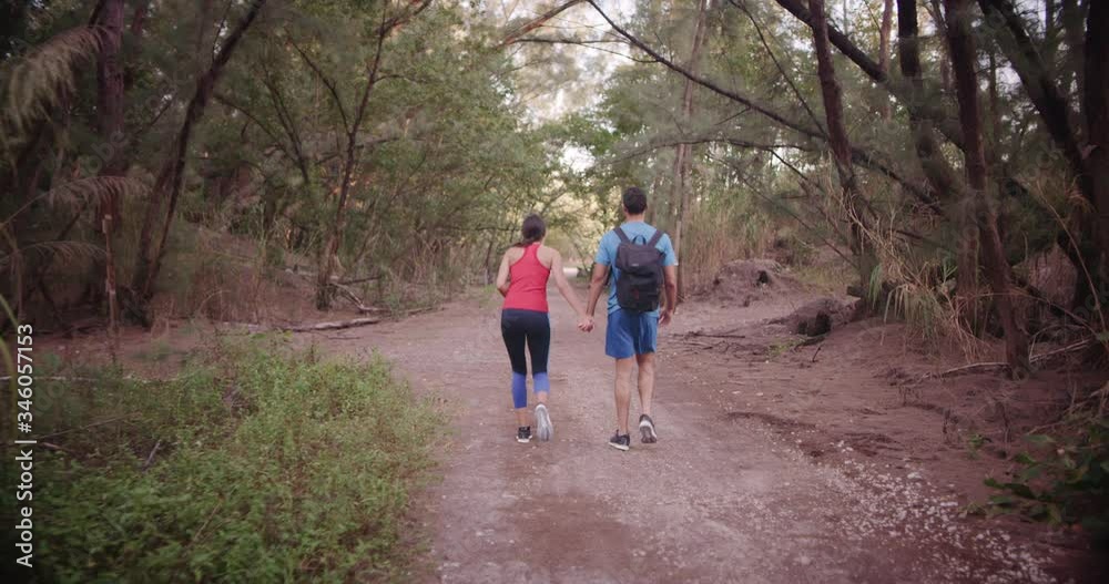 Athletic couple walking together on trail Athletic couple walking together on trail