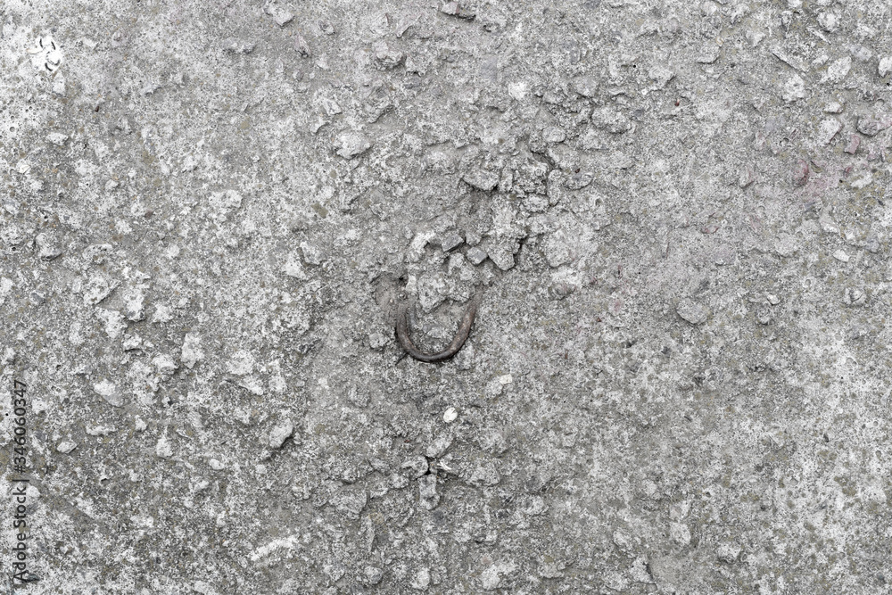 Old concrete slab with a bent metal hook. Background texture Old concrete slab with a bent metal hook. Background texture