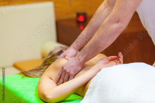 Woman spa. Side view on female enjoying relaxing back massage in cosmetology spa centre