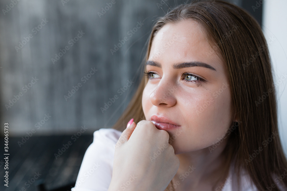 Close-up portrait of a crying girl with spreading make-up holding her hand at mouth. Stress due to work and problems in life. Close-up portrait of a crying girl with spreading make-up holding her hand at mouth. Stress due to work and problems in life.