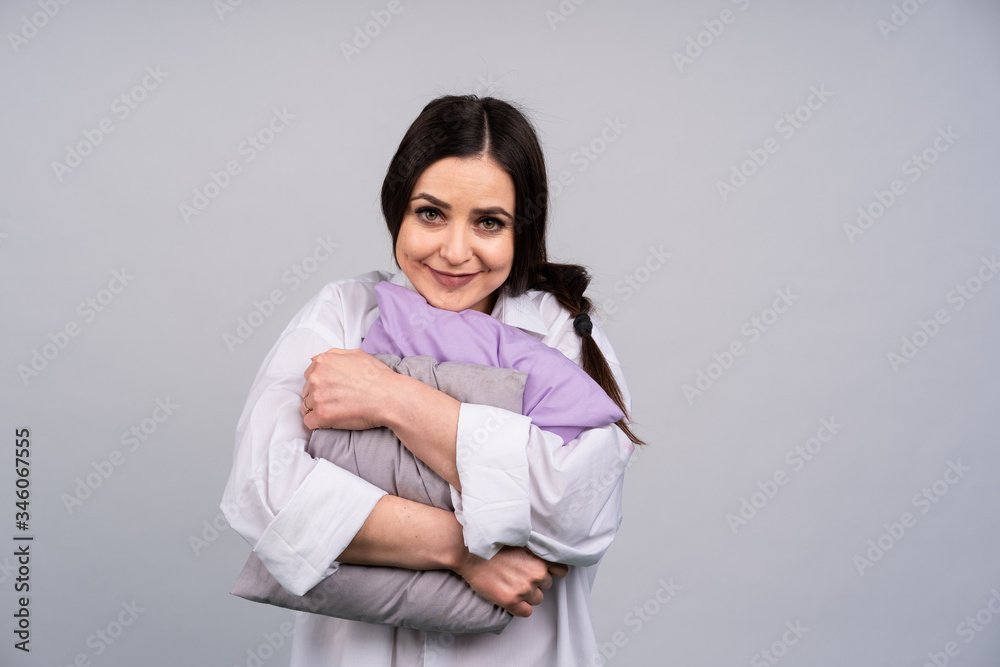 Cute girl in home clothes and hugging my pillow smiling, dark hair in a braid, the concept of comfort and home Cute girl in home clothes and hugging my pillow smiling, dark hair in a braid, the concept of comfort and home