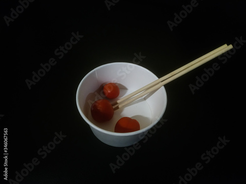 white bowl and chopsticks isolated on black background