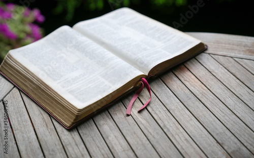 Open bible on wooden table. Soft focus. Copy space.