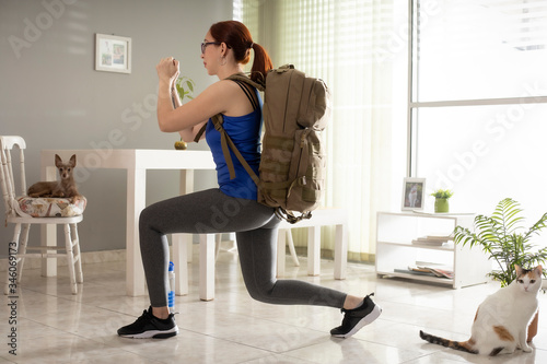 girl in isolation doing leg exercise with briefcase accompanied by pets
