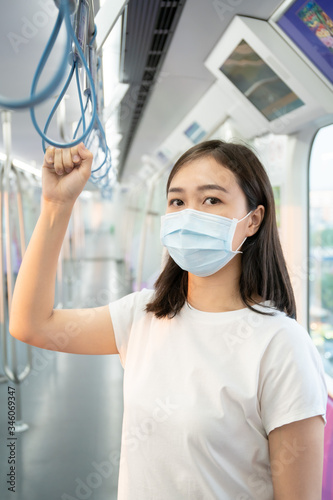 Beautiful young Asian woman wearing the protective mask while traveling in the city where fully with air pollution pm2.5. World critical COVID19 disease, woman wearing hygiene mask to protect COVID-19