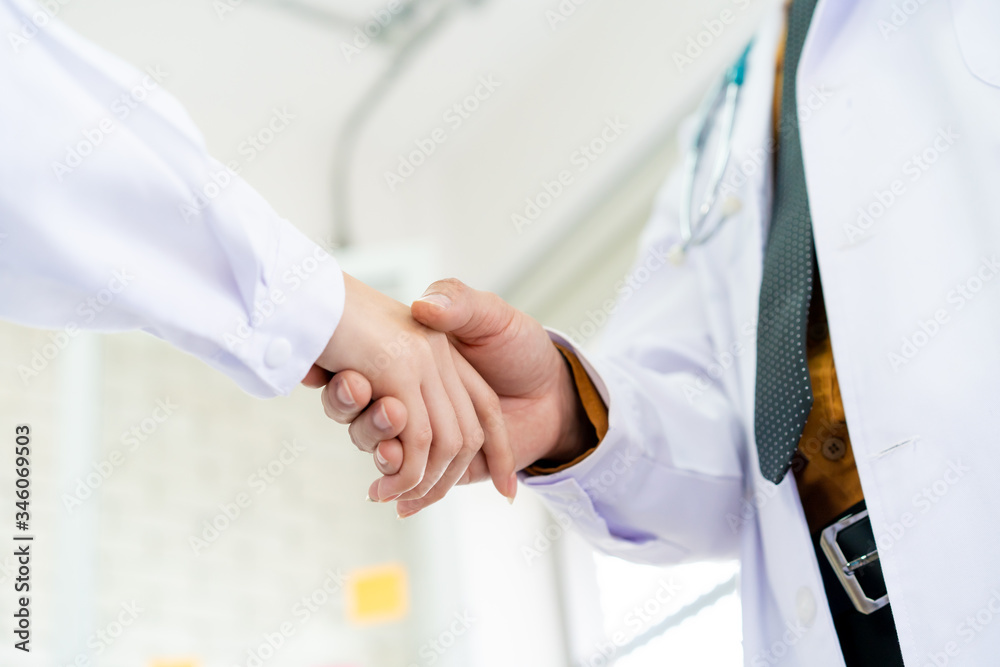 Two senior specialist doctor making a handshake together, trust and good teamwork in medical service in hospital. Concept of collaborative medical partnership in medical service and enterprise. Two senior specialist doctor making a handshake together, trust and good teamwork in medical service in hospital. Concept of collaborative medical partnership in medical service and enterprise.