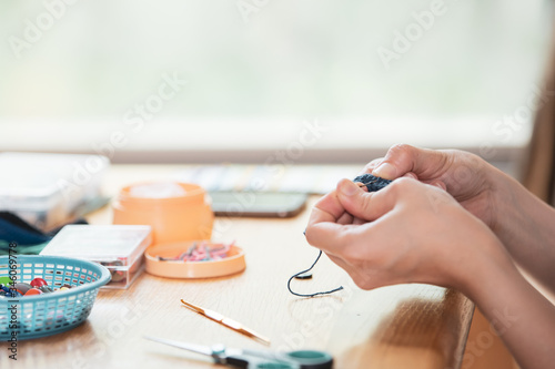 Young woman spending her free time with the handcraft hobby. Skillful woman making a crochet hat and bag during stay at home. The inspiration and creativity work concept with copy space.