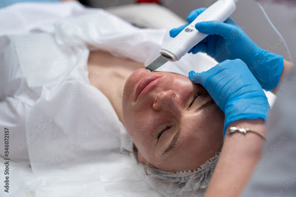 Beautician does facial skin cleansing for his client. Cleansing the skin with special tools. Facial cleansing mask. Beautician does facial skin cleansing for his client. Cleansing the skin with special tools. Facial cleansing mask.