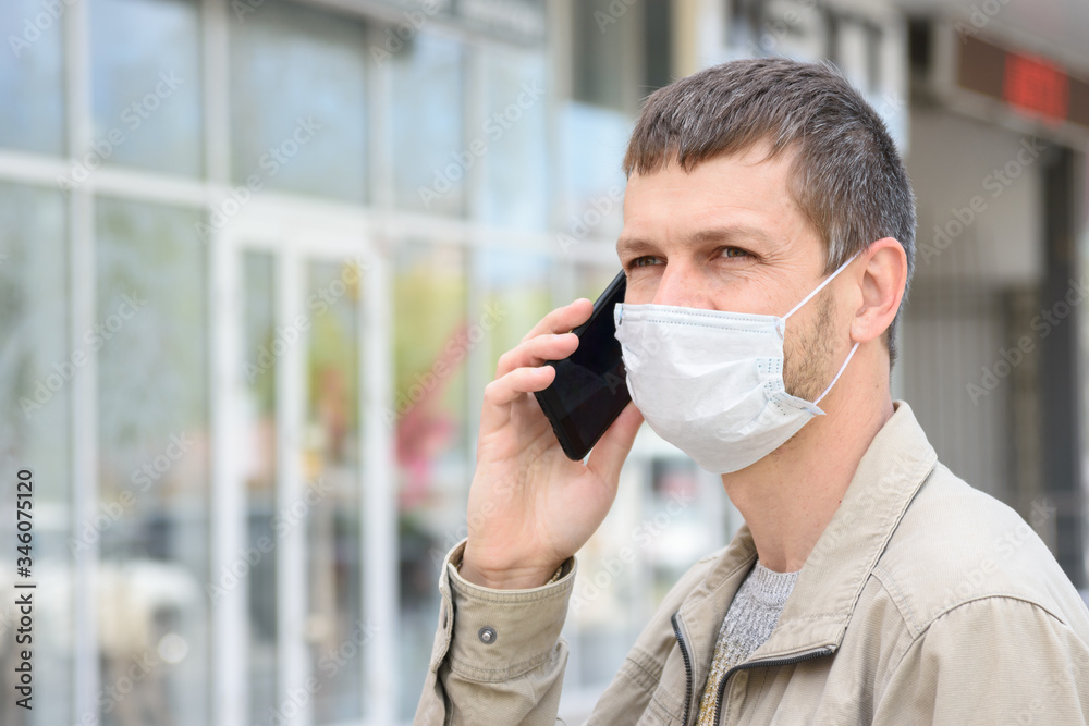 Portrait of a masked man with a mobile phone in the background of the store Portrait of a masked man with a mobile phone in the background of the store