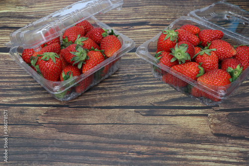 Fresh strawberries placed on a wood grain table top view .