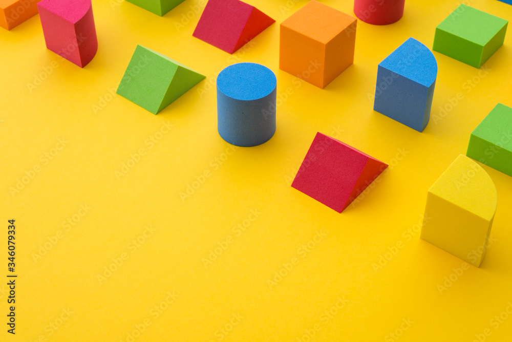Set of colorful geometric cube or block toy on yellow background with ...