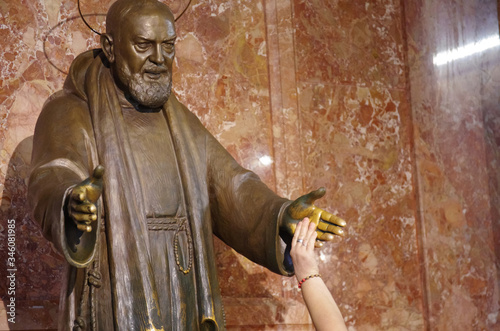San Giovanni Rotondo - Foggia - Puglia - Italy -18 September 2016 - Statue of Padre Pio, a believer shakes his holy hand. photo
