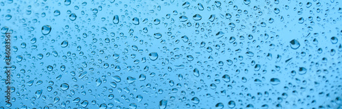 Drops of rain on the window glass. Shallow DOF. Window after rain. Blue Water background with water drops.