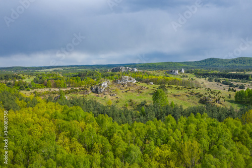 Aerial view of limestone rock formations in green located near Krakow in Poland. Shots from the drone showing the vast green hilly areas of the Cracow-Częstochowa highlands. Kraków-Częstochowa Jura.