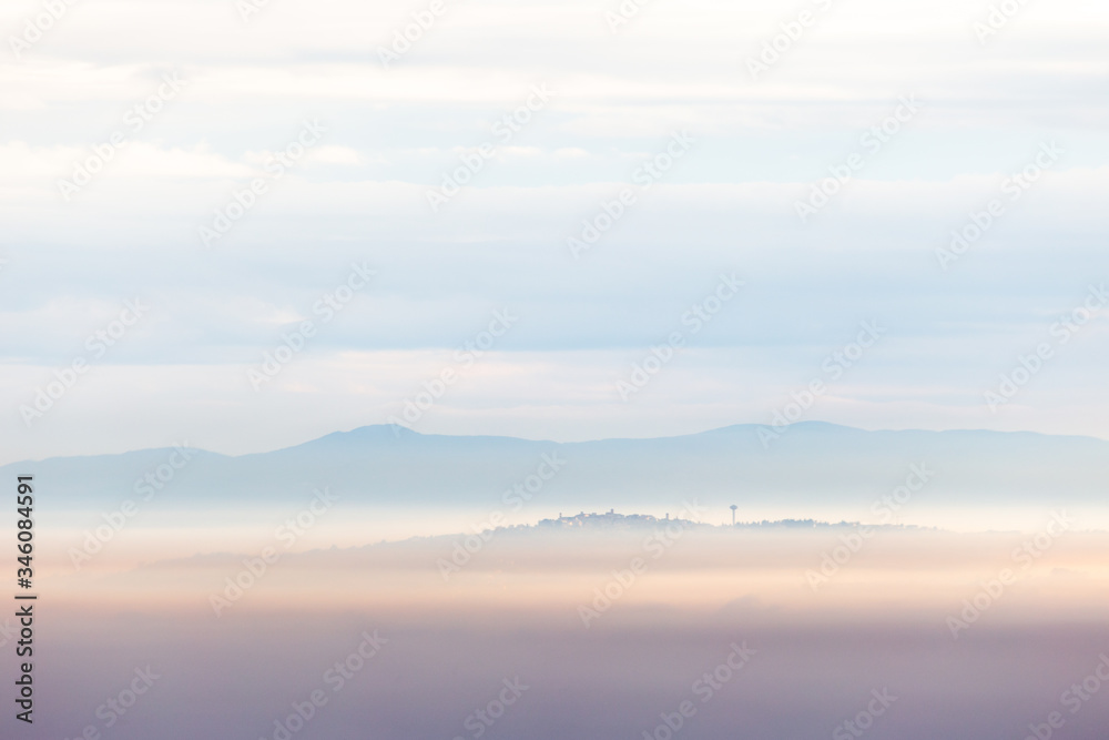 Fog filling a valley in Umbria (Italy), with layers of mountains and hills