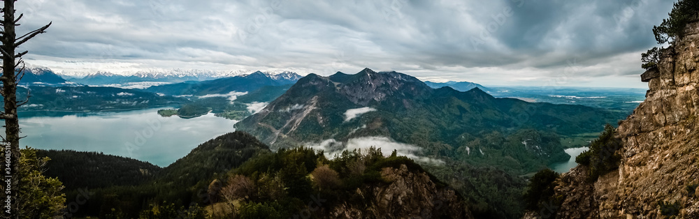 Panorama view over the mountains with clouds and fog and lake