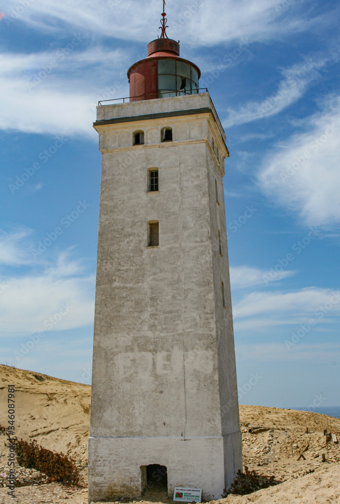 LIghthouse with blue sky and clouds råbjerg knude in skagen denmark LIghthouse with blue sky and clouds råbjerg knude in skagen denmark