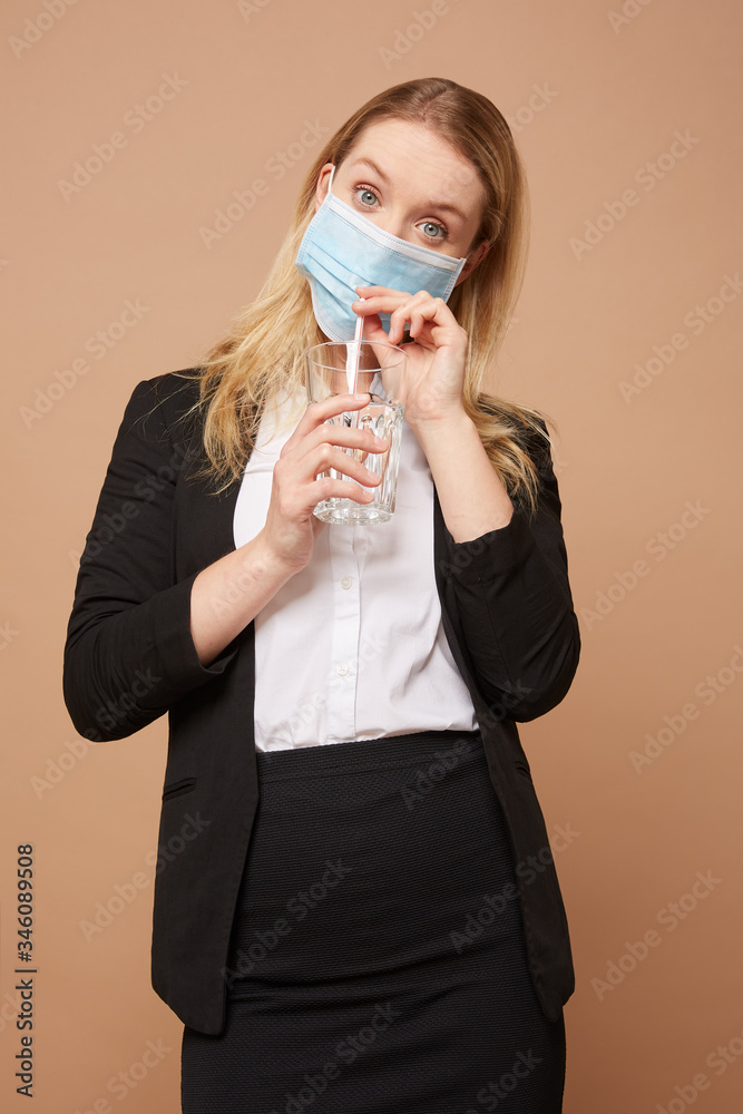 Beautiful busniess women drinks in a mask with a straw Beautiful busniess women drinks in a mask with a straw