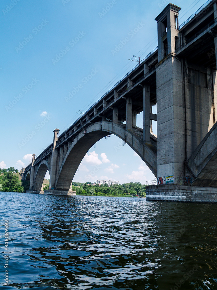 beautiful view of the bridge from the surface of the water. bridge, river, sky