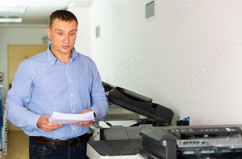 Businessman working with printer in the office