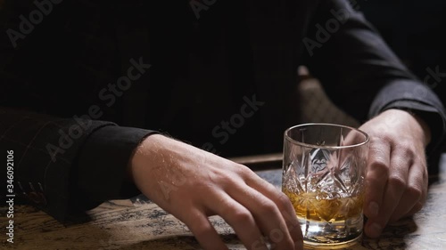 hands with glass on bar,glass rolling on table,man at bar,bokeh,bartender puts ice and takes glass of Bourbon, whiskey.order at bar,splashes of alcohol,concept alcohol, bar.Close-up, 4k
