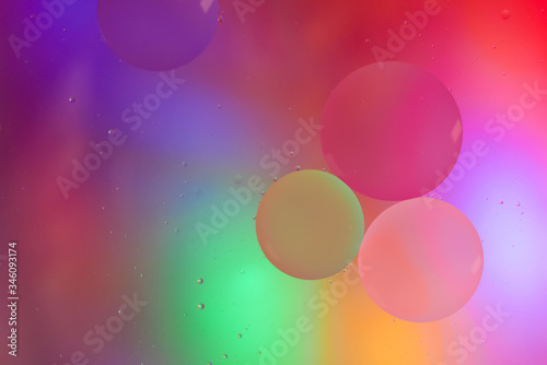 Top view movement of oil bubbles in the liquid. Oil surface multicolored background. Fantastic structure of colorful bubbles. Colorful artistic image of oil drop floating on the water