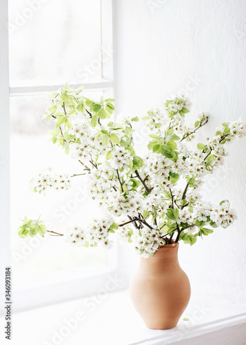 branches of a flowering pear in a vase in a clay pot