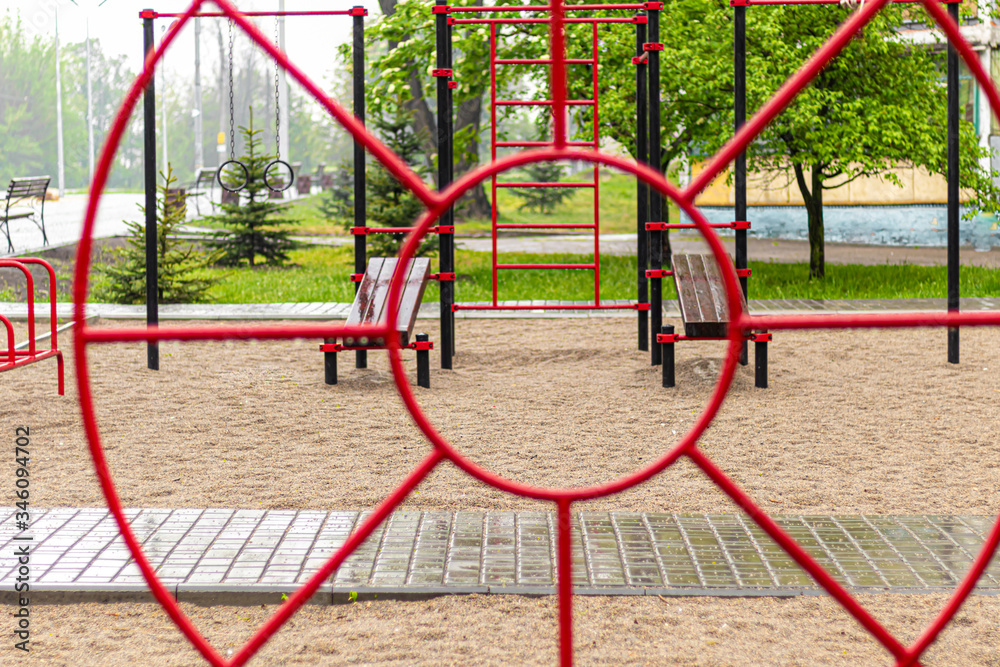 Empty swing at the playground in the rain. Children's swing in the park, wooden benches, slides, sports equipment. Empty city, quarantine. Empty swing at the playground in the rain. Children's swing in the park, wooden benches, slides, sports equipment. Empty city, quarantine.