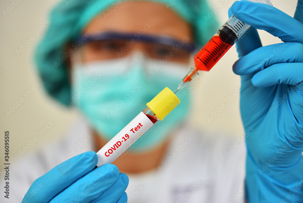 Lab technician holding blood sample tube for COVID-19 test Lab technician holding blood sample tube for COVID-19 test