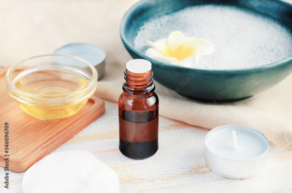 Beauty treatment with essential oils, aroma oil glass dropper bottle, skin cleansing water in blue bowl, coconut oil in small jar on table, closeup home spa set.
Beauty treatment with essential oils, aroma oil glass dropper bottle, skin cleansing water in blue bowl, coconut oil in small jar on table, closeup home spa set.