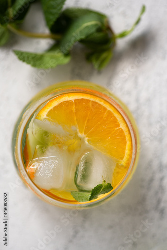 Top view of lemonade with lemon, oranges and peppermint with ice cubes. Glass of lemonade on a table