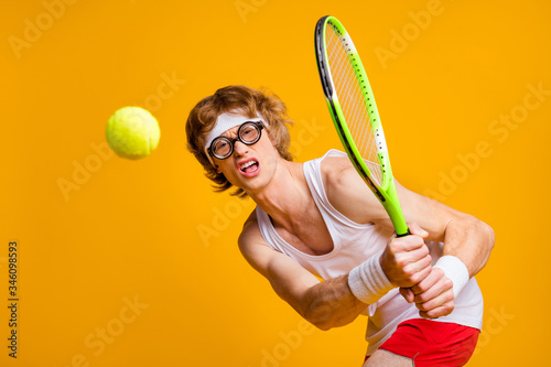 Portrait of his he nice funky muscular motivated successful guy playing court tennis spending vacation weekend professional gamer isolated over bright vivid shine vibrant yellow color background