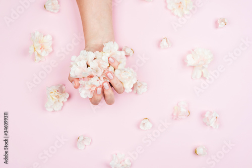 Delicate female manicure on a pink background