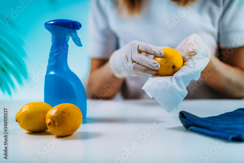 Disinfecting Fruit. Woman Disinfecting Lemon with Wipes and Alcohol based disinfectant photo