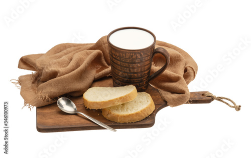 milk in a ceramic mug with bread on a kitchen board