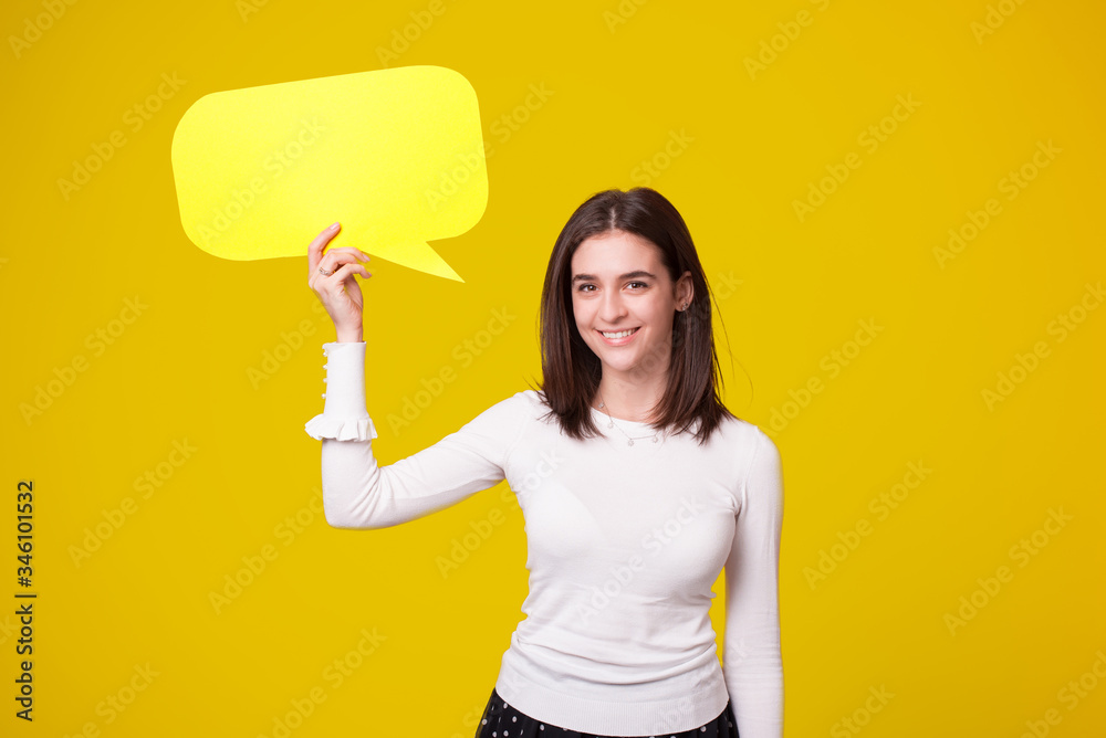 Young smiling woman is holding over her head a yellow bubble speech. Young smiling woman is holding over her head a yellow bubble speech.